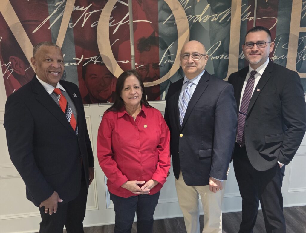 Standing with Mayor in front of a VOTE banner
